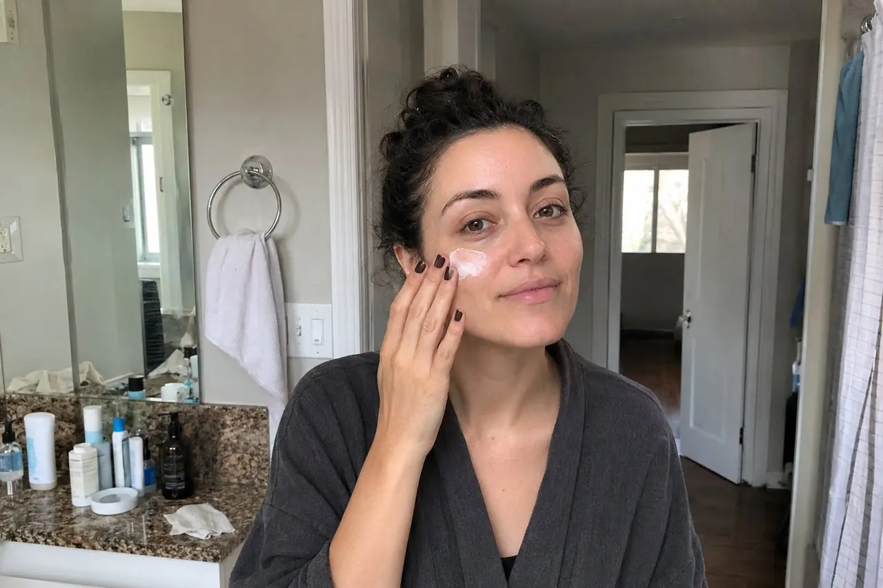 A woman applying La Roche-Posay Toleriane Double Repair moisturizer to her cheek